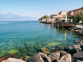 Scenic view of Lake Garda with mountains and a quiet lakeside village at sunset